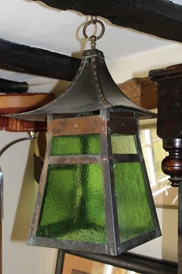 Lot 1546 - Art and crafts anodised copper lantern in the manner of Benson, loop suspension and pagoda roof, of flared form with green textured glass panels, 58cm high