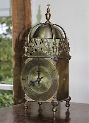 Lot 1561 - 17th century style brass lantern clock, typical form with surmounting bell and brass chapter dial on turned feet, 30cm