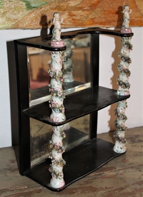 Lot 1656 - Antique wall hanging shelves with mirrored back and mahogany shaped shelves between porcelain floral encrusted spiral turned columns, 24cm wide x 35cm high
