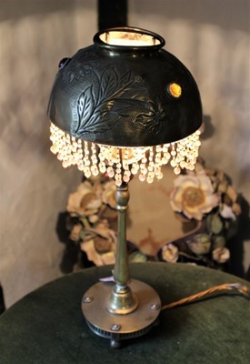 Lot 1659 - Arts and Crafts brass table lamp, the hemispherical shade inset with glass studs and hanging beads, on slender column with platform base, 49cm high