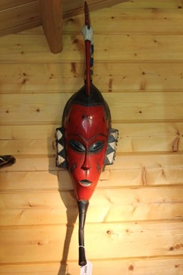 Lot 1694 - African painted Guro mask of typical elongated form with bird cresting, 81cm high, together with two African paddles and an African hide drum (4)