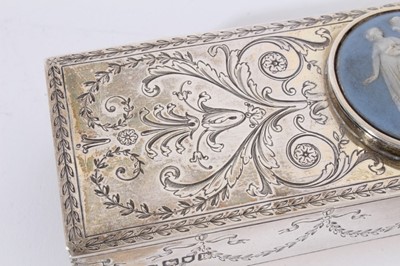 Lot 417 - Edwardian silver match box holder of rectangular form with engraved decoration and central Jasperware panel inset to the top, raised on four ball feet, (London 1905), maker E D, 16cm in length