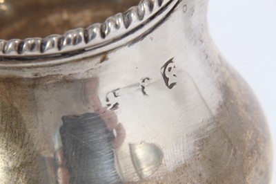 Lot 420 - George III silver cream jug of baluster form with gadrooned borders and scroll handle, raised on domed circular foot, (London 1773), together with another Georgian III silver cream jug