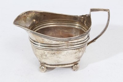 Lot 420 - George III silver cream jug of baluster form with gadrooned borders and scroll handle, raised on domed circular foot, (London 1773), together with another Georgian III silver cream jug
