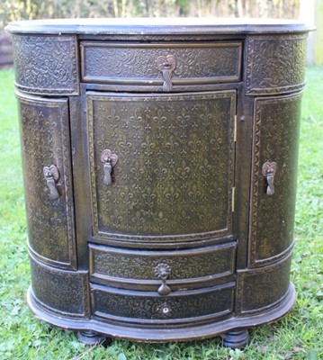 Lot 1789 - Decorative side cabinet of lobed form covered in tooled paper, enclosed by an arrangement of drawers and cupboards 63cm wide x 38cm deep x 66cm high