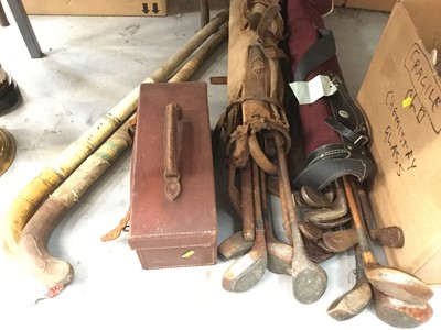 Lot 344 - Two bags of vintage golf clubs, bowling woods in leather case and hockey sticks