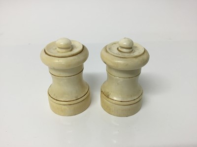 Lot 550 - Pair of early 20th century turned ivory pepper grinders of waisted form, 7cm high