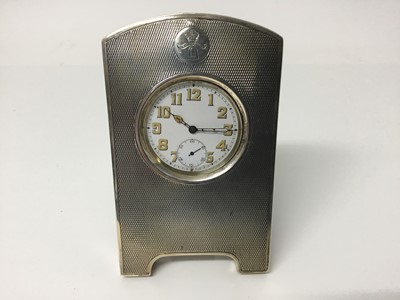 Lot 551 - 1920s silver pocket watch holder with engine turned decoration and engraved crest, with leather covered easel back (London 1923) and stainless steel pocket watch with luminous numbers, 12.5cm high...