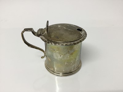 Lot 553 - 1920s silver drum mustard pot with gadrooned border and shell formed thumb-piece, with blue glass liner (Chester 1923), 7.5cm high overall, 4ozs