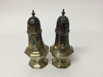 Lot 554 - Pair of late Victorian silver octagonal pepperettes with engraved crests (London 1898), 11.5cm high, 4.2ozs