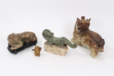 Lot 759 - Four Chinese carvings, including a horn figure, a bronze beast on a hardstone base, a jadeite foo dog, and an unusual stone foo dog on a wooden base