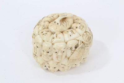 Lot 831 - Meiji period ivory trinket box carved with 33 character masks from the Noh Theatre, detachable inset cover engraved on inside with a man’s face, underside of box with Japanese signature. 4cm overal...