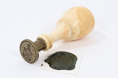 Lot 835 - 19th century desk seal, with oval brass matrix, engraved with an armorial shield and crest and turned ivory handle. 10cm overall height.