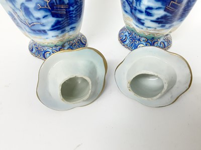 Lot 165 - Pair of early 19th century Masons twin-handled stoneware vases, and covers, decorated in underglaze blue, enamels and gilt with Chinese landscape scenes, pseudo-seal marks to bases, 26cm high