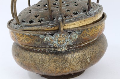 Lot 879 - 17th century brass censer, with pierced domed cover and surmounting cage, the squat vessel with foliate ornament and swing handle, 18cm diameter 
Provenance: Estate of the Late Jane Sumner