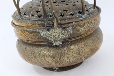 Lot 879 - 17th century brass censer, with pierced domed cover and surmounting cage, the squat vessel with foliate ornament and swing handle, 18cm diameter 
Provenance: Estate of the Late Jane Sumner