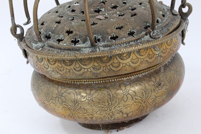 Lot 879 - 17th century brass censer, with pierced domed cover and surmounting cage, the squat vessel with foliate ornament and swing handle, 18cm diameter 
Provenance: Estate of the Late Jane Sumner