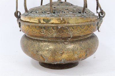 Lot 879 - 17th century brass censer, with pierced domed cover and surmounting cage, the squat vessel with foliate ornament and swing handle, 18cm diameter 
Provenance: Estate of the Late Jane Sumner