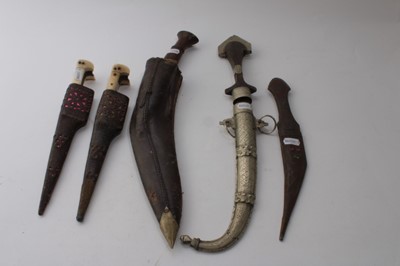 Lot 858 - Old Gurkha Kukri in leather covered sheath, together with two Persian Kabz daggers and two other Eastern daggers (5)