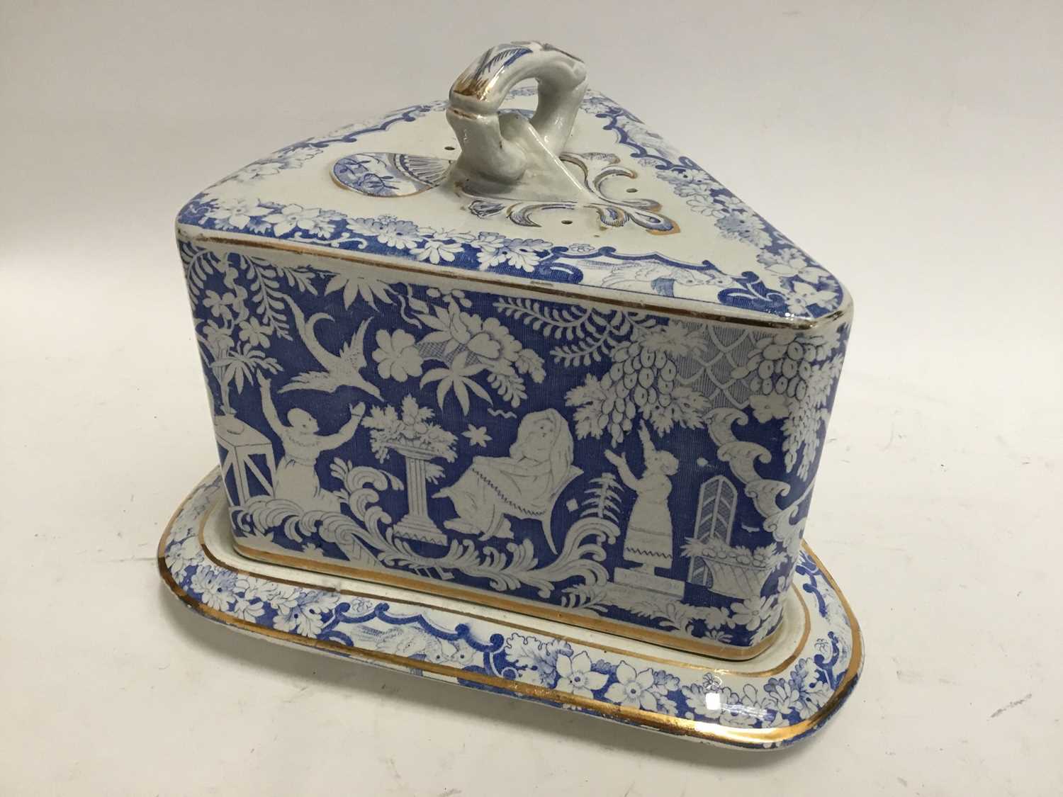 Lot 781 - Late Victorian/Edwardian blue and white cheese dish and cover of triangular form, decorated with classical scenesc