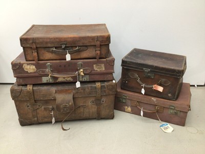 Lot 141 - Late Victorian leather trunk by Finnigan, Manchester, together with four other vintage leather suitcases with labels (5)