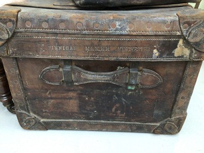 Lot 141 - Late Victorian leather trunk by Finnigan, Manchester, together with four other vintage leather suitcases with labels (5)