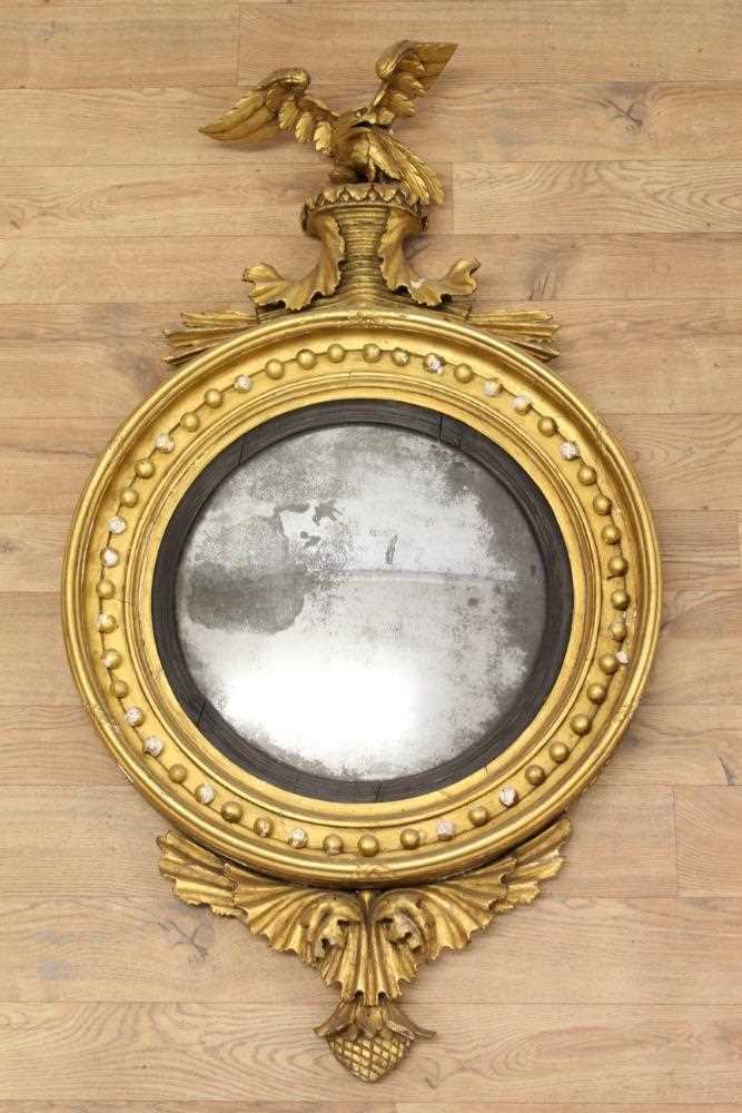 Lot 1393 - Regency gilt framed convex wall mirror with eagle surmount