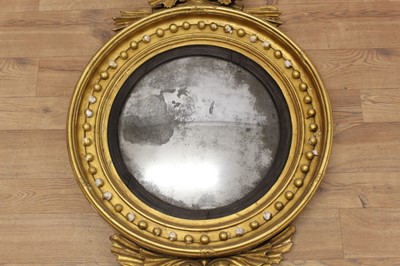 Lot 1393 - Regency gilt framed convex wall mirror with eagle surmount