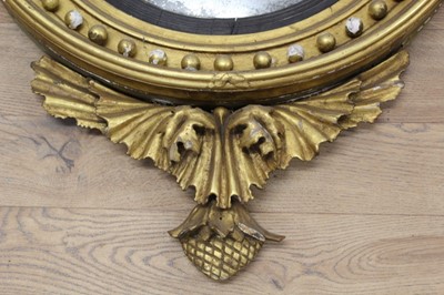 Lot 1393 - Regency gilt framed convex wall mirror with eagle surmount