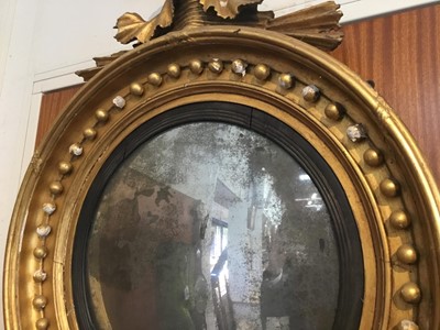 Lot 1393 - Regency gilt framed convex wall mirror with eagle surmount