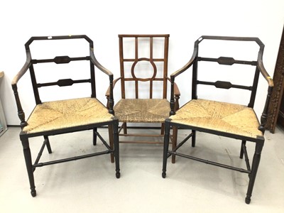 Lot 128 - Pair of rush seated ebonised elbow chairs, together with another (3)