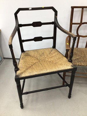 Lot 128 - Pair of rush seated ebonised elbow chairs, together with another (3)