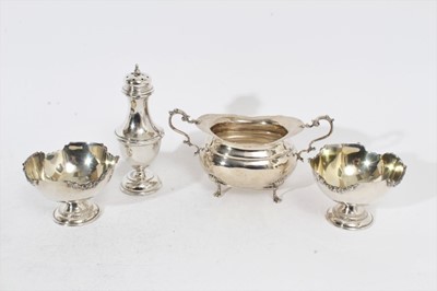 Lot 311 - Edwardian silver sugar bowl of cauldron form with twin scroll handles, raised on four scroll feet, (Sheffield 1907), together with an Edwardian silver sugar caster (Birmingham 1908) and a pair of s...