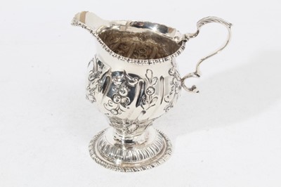 Lot 315 - George III silver milk / cream jug of baluster form with embossed decoration and scroll handle, raised on circular foot, (London 1764), makers mark rubbed, all at approximately 5oz, 10.5cm in heigh...