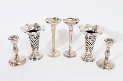 Lot 327 - Pair of Edwardian silver spill vases of trumpet form with pierced decoration and blue glass liners (Chester 1904), together with another pair of silver spill vases, (Chester 1915) and a pair of sil...