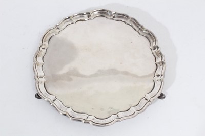 Lot 333 - Georgian Silver salver of circular form with piecrust borders, raised on three hoof feet, marked rubbed all at approximately 17oz, 23cm in diameter