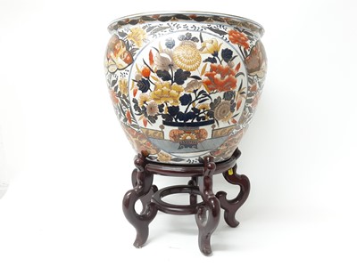 Lot 163 - Large pair of Japanese Imari fishbowls on wooden stands, painted with flowers and birds, with goldfish inside