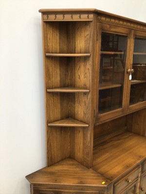 Lot 103 - Ercol lounge unit to include two height bookcase with glazed doors above enclosing two adjustable shelves with two drawers and cupboard doors below, corner unit with three fixed shelves above and s...