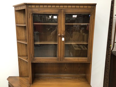 Lot 103 - Ercol lounge unit to include two height bookcase with glazed doors above enclosing two adjustable shelves with two drawers and cupboard doors below, corner unit with three fixed shelves above and s...