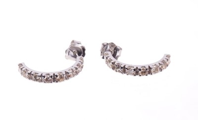 Lot 481 - Pair of diamond half hoop earrings, each with eight brilliant cut diamonds in white gold setting, estimated total diamond weight approximately 1.44cts. Diameter approximately 20mm.