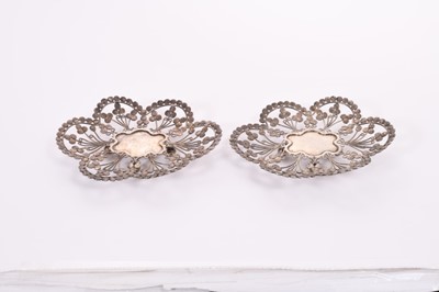 Lot 354 - Pair of antique eastern, possibly Persian white metal flower head dishes, with Islamic coin style decoration, each raised on four ball feet, all at 8oz, 15cm in length (2)