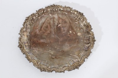 Lot 359 - Edwardian silver salver with pie crust edge and scroll border, raised on three scroll feet (London 1909), maker W & C Sissons, all at approximately 21oz, 26cm in diameter