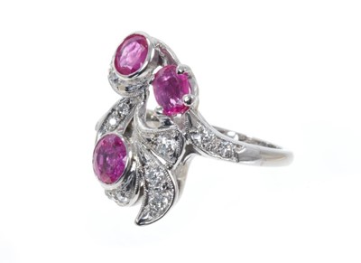 Lot 498 - Art Nouveau style ruby and diamond cocktail ring with three mixed cut rubies, old cut and brilliant cut diamonds in foliate scrolls on 14ct white gold shank. Finger size approximately K.