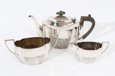Lot 390 - Late Victorian silver three piece teaset comprising teapot of oval form with fluted decoration, domed hinged cover with ebony finial and ebony