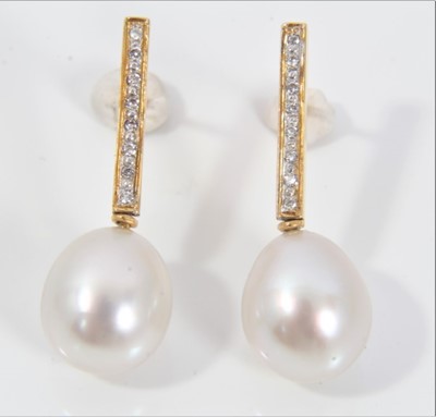 Lot 521 - Pair of cultured pearl and diamond pendant earrings, each with a pear shape cultured pearl measuring approximately 11.3 x 9.8mm, suspended from a diamond set gold bar with pierced fittings, length...