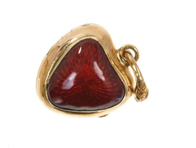 Lot 525 - Victorian gold and red enamel heart shaped locket enclosed by glazed front with intaglio engraved gothic 'A', the reverse with red guilloche enamel and suspended from a snake loop. 25mm x 15mm.