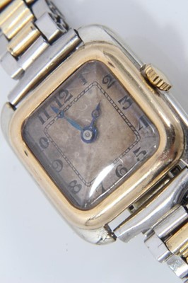 Lot 554 - 1920s gold and stainless steel wristwatch with square silvered dial, black enamel Arabic numerals and blued steel hands, gold bezel and gold winding crown in stainless steel case with 18ct gold bac...