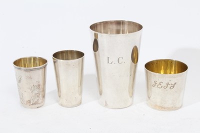 Lot 371 - Group of four various Continental silver and white metal beakers of tapered cylindrical form, to include two German silver beakers, a Russian beaker by Ivan Zinovbev Manilov in Kostroma and one oth...