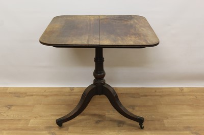 Lot 1410 - Regency mahogany occasional table, with rounded rectangular tilt-top on ring turned column and reeded tripod supports on brass cappings and castors, 70cm wide