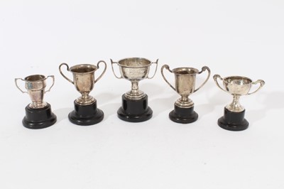 Lot 378 - George V silver miniature two handled trophy cup (Birmingham 1932), together with four other miniature silver trophy cups (various dates and makers), all at 7oz, largest cup 7cm in height.